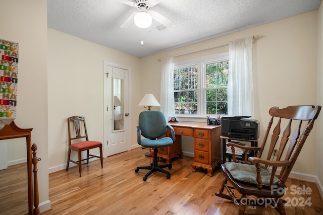 office area with ceiling fan, a textured ceiling, and light wood-type flooring