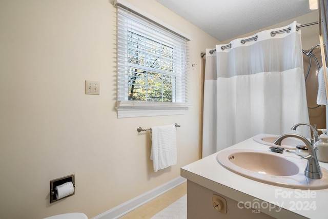 bathroom featuring vanity, a textured ceiling, and toilet