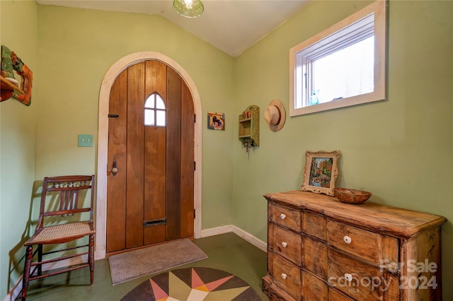 entryway with lofted ceiling and dark carpet