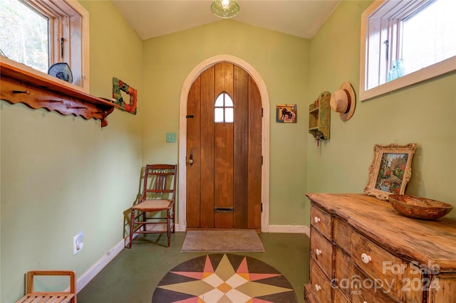 entryway with plenty of natural light, carpet floors, and vaulted ceiling