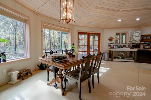 dining space with french doors, a notable chandelier, sink, and wooden ceiling