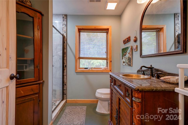 bathroom with vanity, toilet, and a tile shower