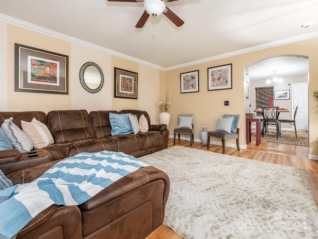 living room featuring crown molding, light hardwood / wood-style floors, and ceiling fan with notable chandelier