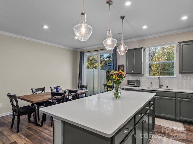 kitchen with sink, a kitchen island, hanging light fixtures, and gray cabinetry