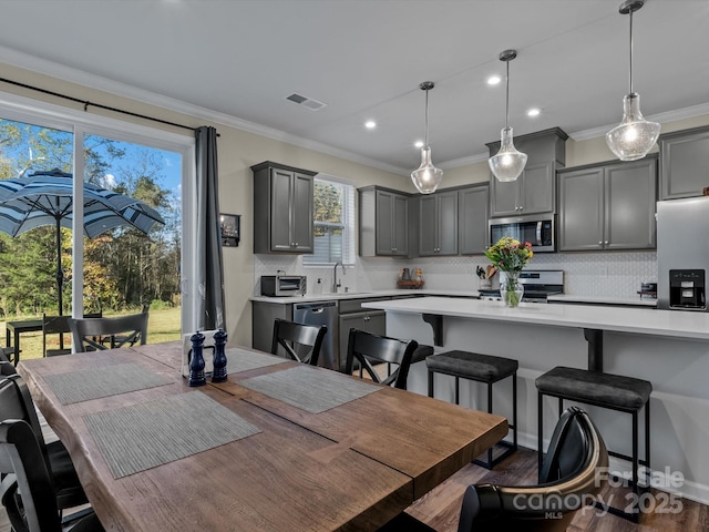 dining space featuring sink, ornamental molding, and dark hardwood / wood-style flooring