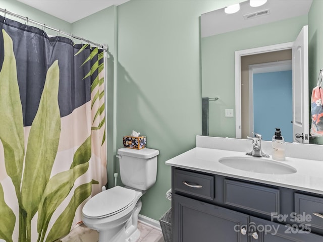 bathroom featuring toilet, vanity, and walk in shower