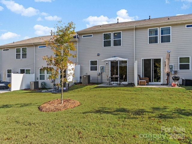 rear view of property featuring central air condition unit, a yard, and a patio