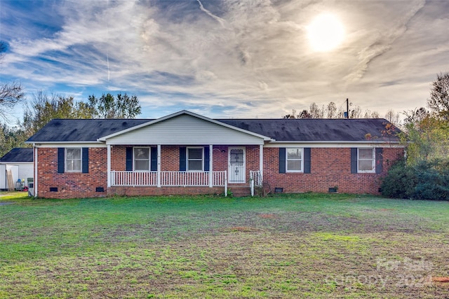 ranch-style house with a porch and a yard