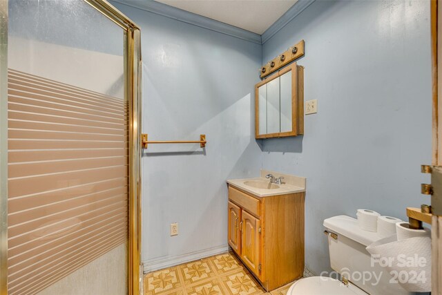 bathroom with vanity, toilet, and ornamental molding