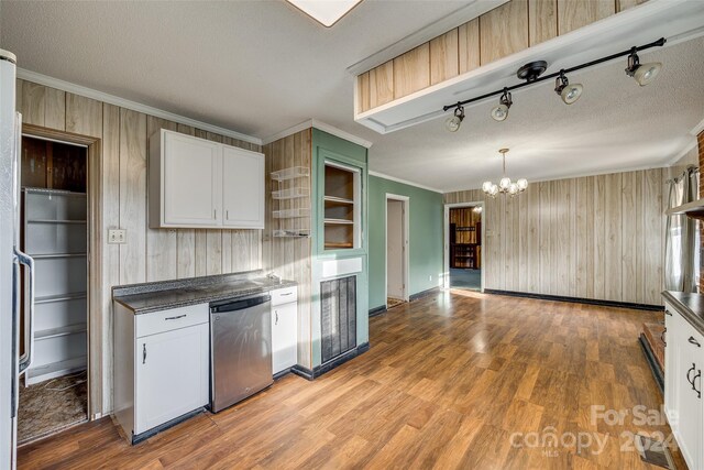 kitchen with dishwasher, light hardwood / wood-style flooring, a chandelier, wooden walls, and white cabinets