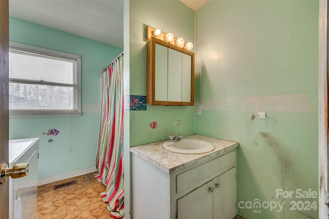 bathroom with a textured ceiling and vanity