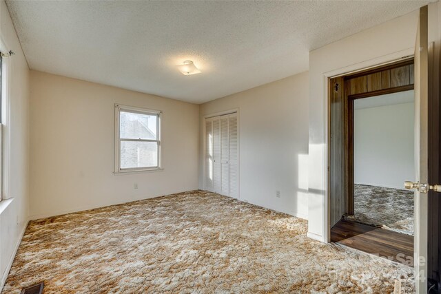 unfurnished room featuring wood-type flooring and a textured ceiling