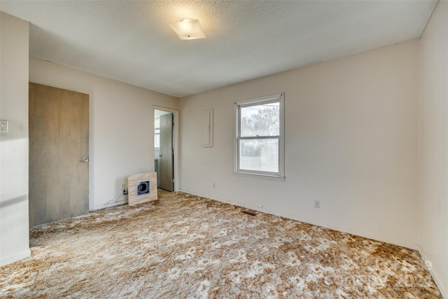 carpeted empty room featuring a textured ceiling