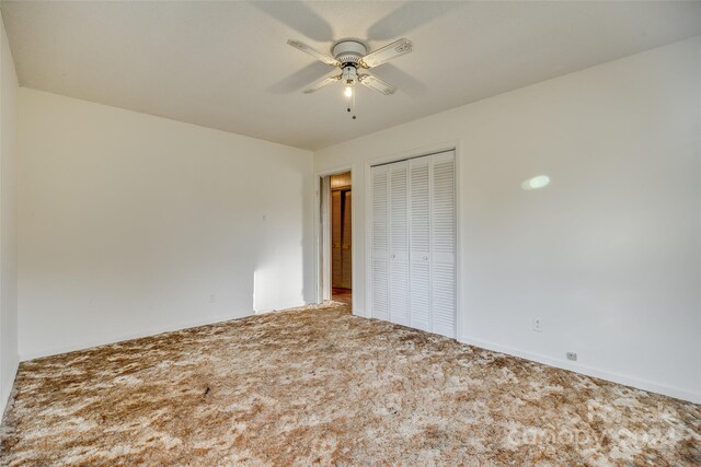 unfurnished bedroom featuring carpet, a closet, and ceiling fan