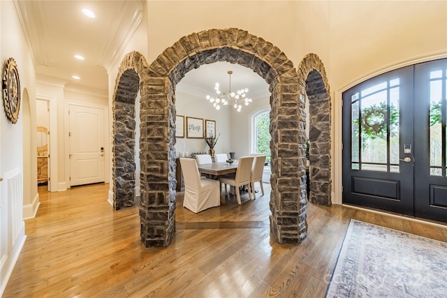 entryway featuring wood-type flooring, a healthy amount of sunlight, and decorative columns