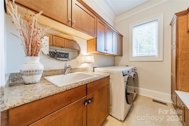 washroom with cabinets, sink, light tile patterned floors, crown molding, and independent washer and dryer