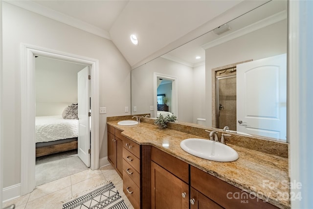 bathroom with ornamental molding, walk in shower, vanity, vaulted ceiling, and tile patterned flooring