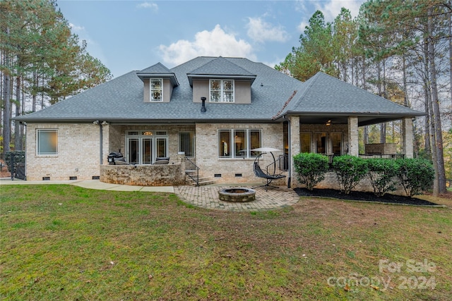 back of property with a patio area, a lawn, and an outdoor fire pit