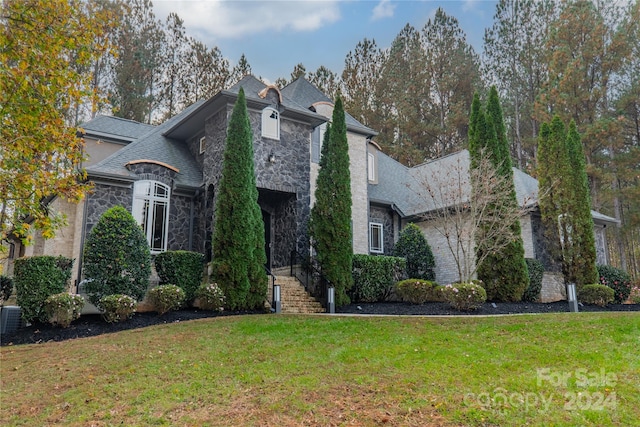 french country inspired facade with a front yard