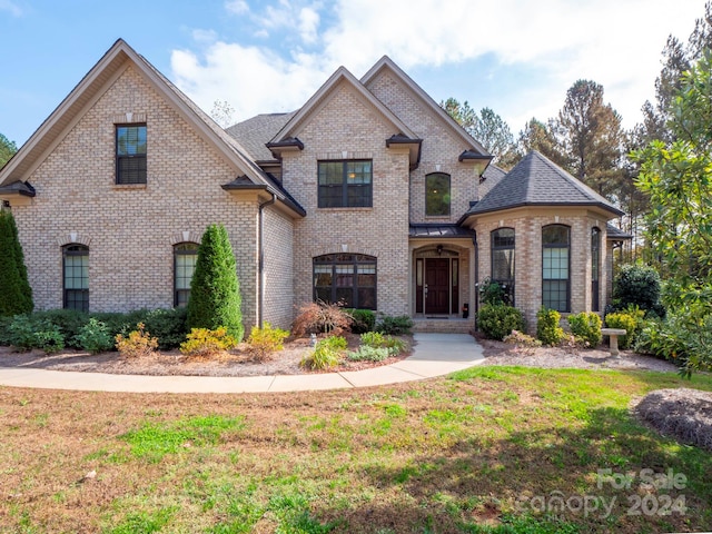 french country home with a front lawn