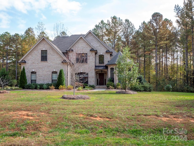 french country inspired facade featuring a front yard