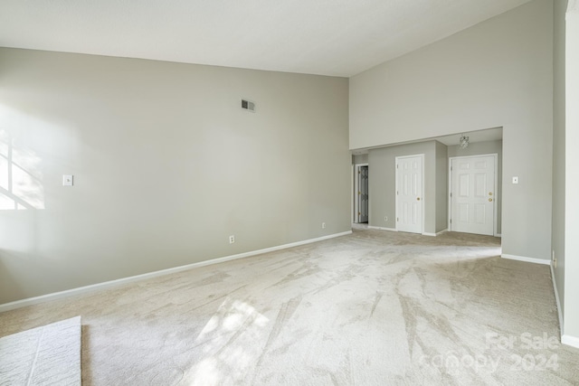 interior space with high vaulted ceiling and light colored carpet