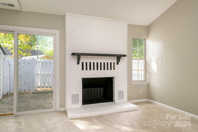 unfurnished living room featuring carpet and a large fireplace