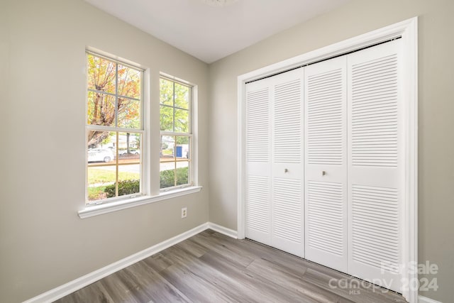 unfurnished bedroom with light hardwood / wood-style floors and a closet