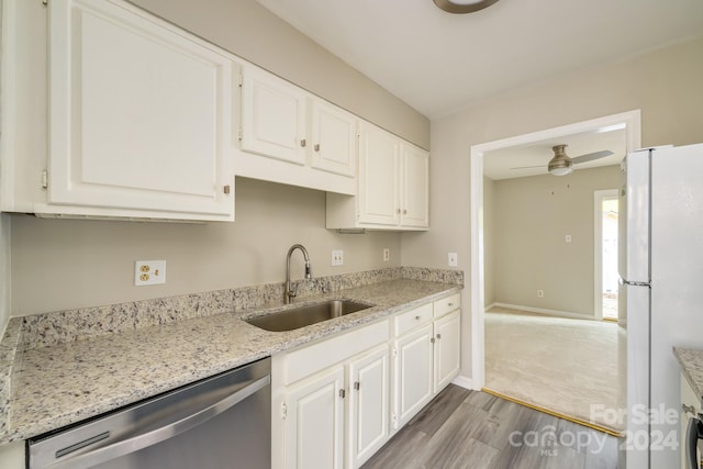 kitchen with stainless steel dishwasher, white refrigerator, sink, and white cabinets