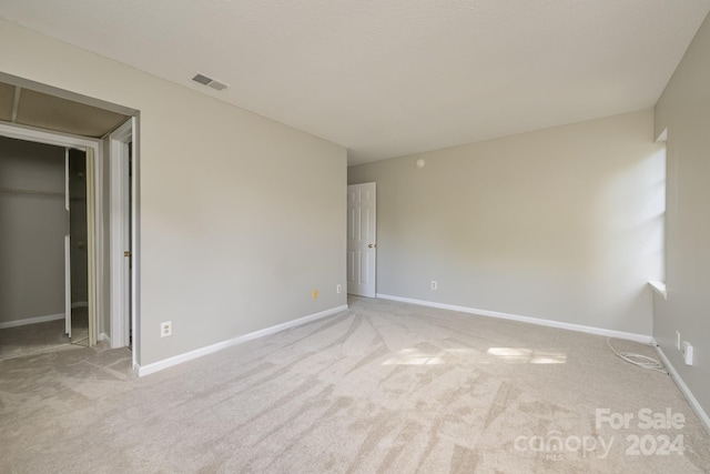 unfurnished room featuring light carpet