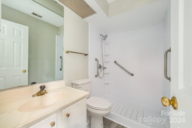 bathroom with toilet, a shower, vanity, and hardwood / wood-style flooring