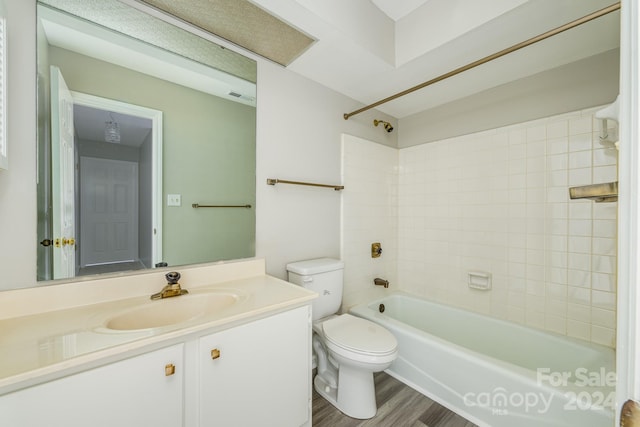 full bathroom with wood-type flooring, toilet, vanity, and tiled shower / bath