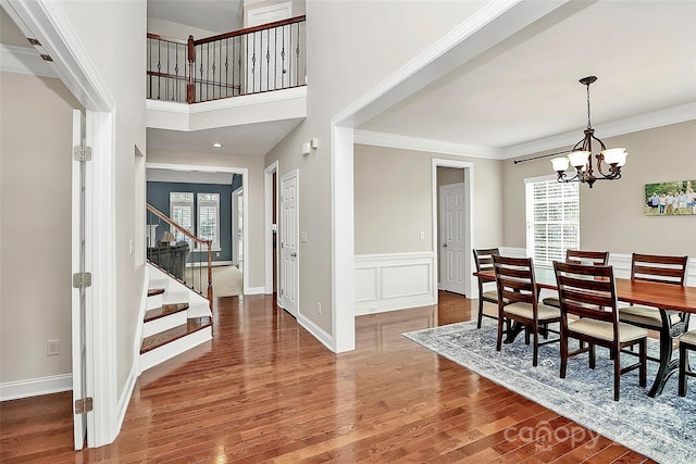 16404 Grassy Creek Dr, Huntersville, NC 28078 - dining area featuring stairs, wood finished floors, a chandelier, ornamental molding, and baseboards