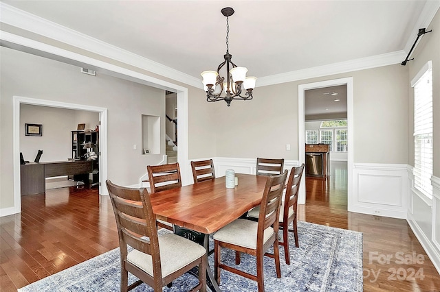 16404 Grassy Creek Dr, Huntersville, NC 28078 - dining room with stairs, wood finished floors, a wainscoted wall, a chandelier, and crown molding