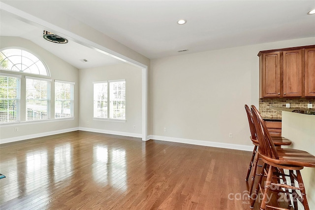 dining area featuring dark wood-type flooring and lofted ceiling