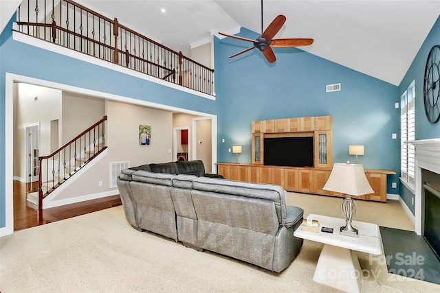 16404 Grassy Creek Dr, Huntersville, NC 28078 - living room featuring high vaulted ceiling, stairway, ceiling fan, a fireplace, and baseboards