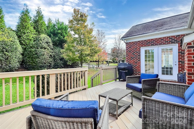 wooden terrace featuring grilling area, a lawn, and an outdoor living space