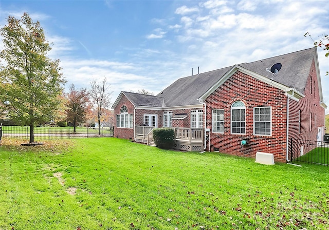 back of house with a deck and a yard