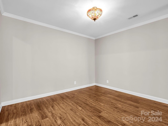 unfurnished room with hardwood / wood-style floors and ornamental molding