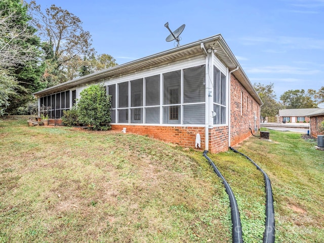 rear view of property with a sunroom and a lawn