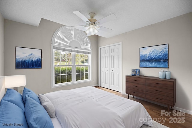 bedroom with ceiling fan, a closet, a textured ceiling, and hardwood / wood-style flooring