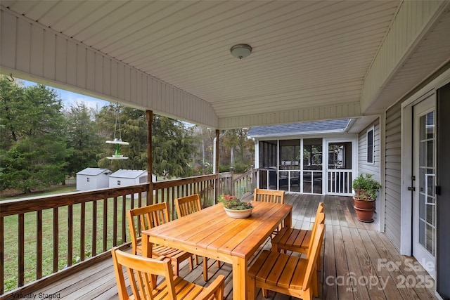 wooden terrace featuring a yard and a sunroom