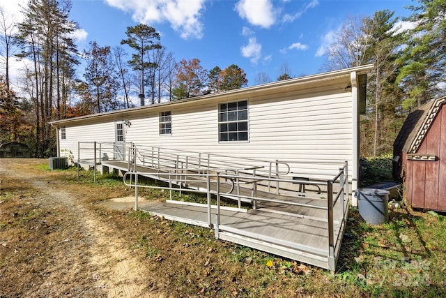 back of property featuring a wooden deck and cooling unit