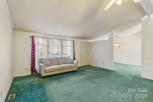 unfurnished living room with ceiling fan, crown molding, and dark carpet