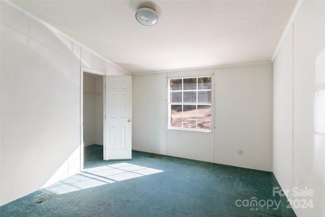 unfurnished bedroom with ornamental molding, a closet, a textured ceiling, and carpet