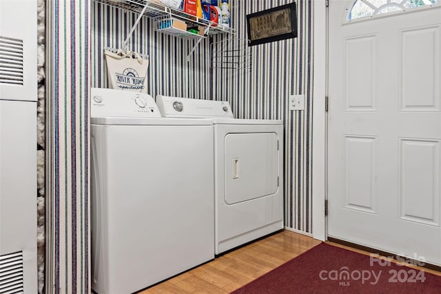 washroom with wood-type flooring and washer and dryer