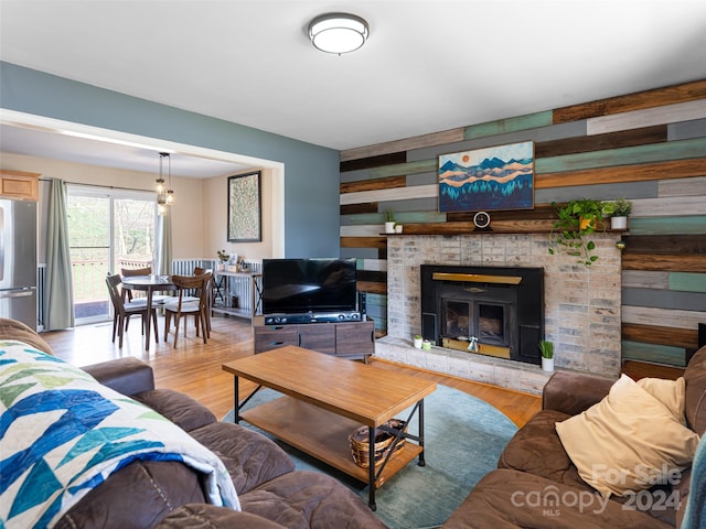 living room featuring light wood-type flooring and wooden walls