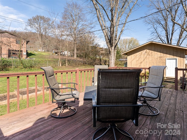 wooden terrace featuring a lawn and a storage shed