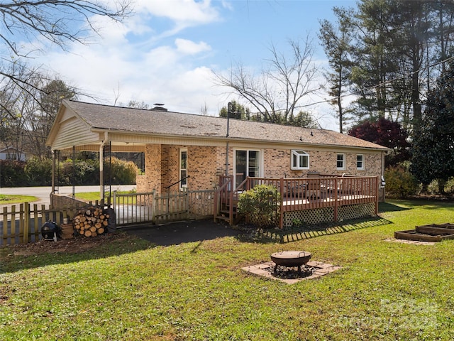 back of property with a patio area, a yard, a fire pit, and a wooden deck