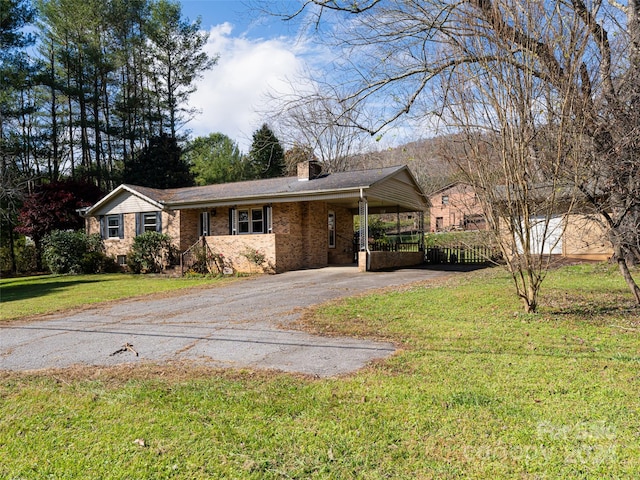 ranch-style house featuring a front lawn and a carport